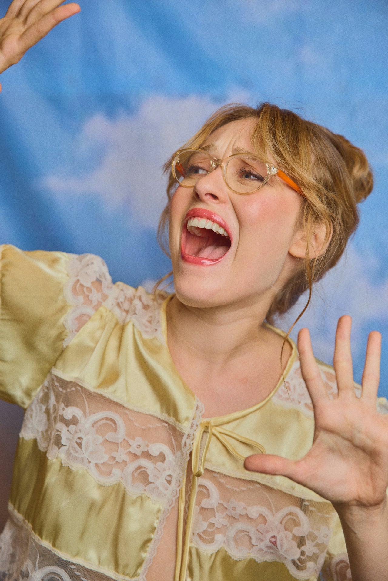 A lady looking alarmed wearing a yellow lace top with a blue sky and clouds in the background, representing the Immediate Need eCommerce marketing category