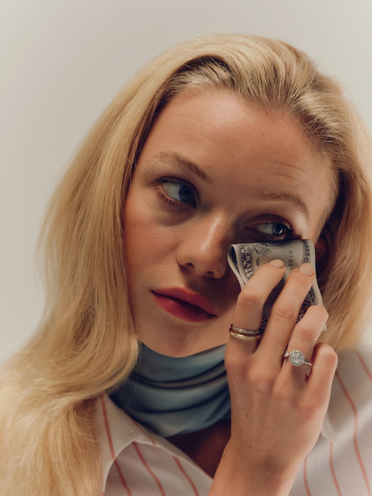 Alt: Woman holding a dollar bill, representing high-ticket pricing and profitability 